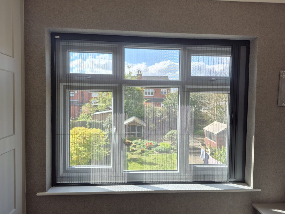 Black-framed Blind Screen system open across a wide bedroom window